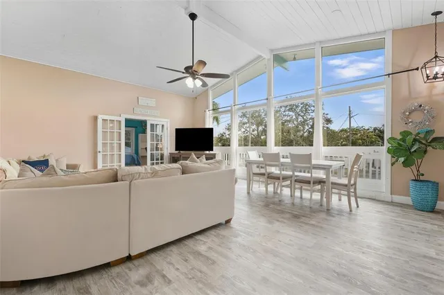 a living room with furniture a chandelier and a flat screen tv