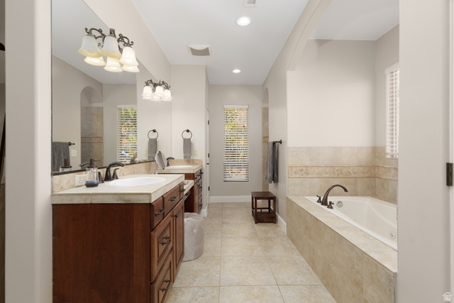 1257 West 2320 South St. George, UT 84770 - Photo 20 of 55 Bathroom featuring a built-in soaking tub with tile surround, dual vanity with wood cabinetry and stone countertops, and recessed lighting