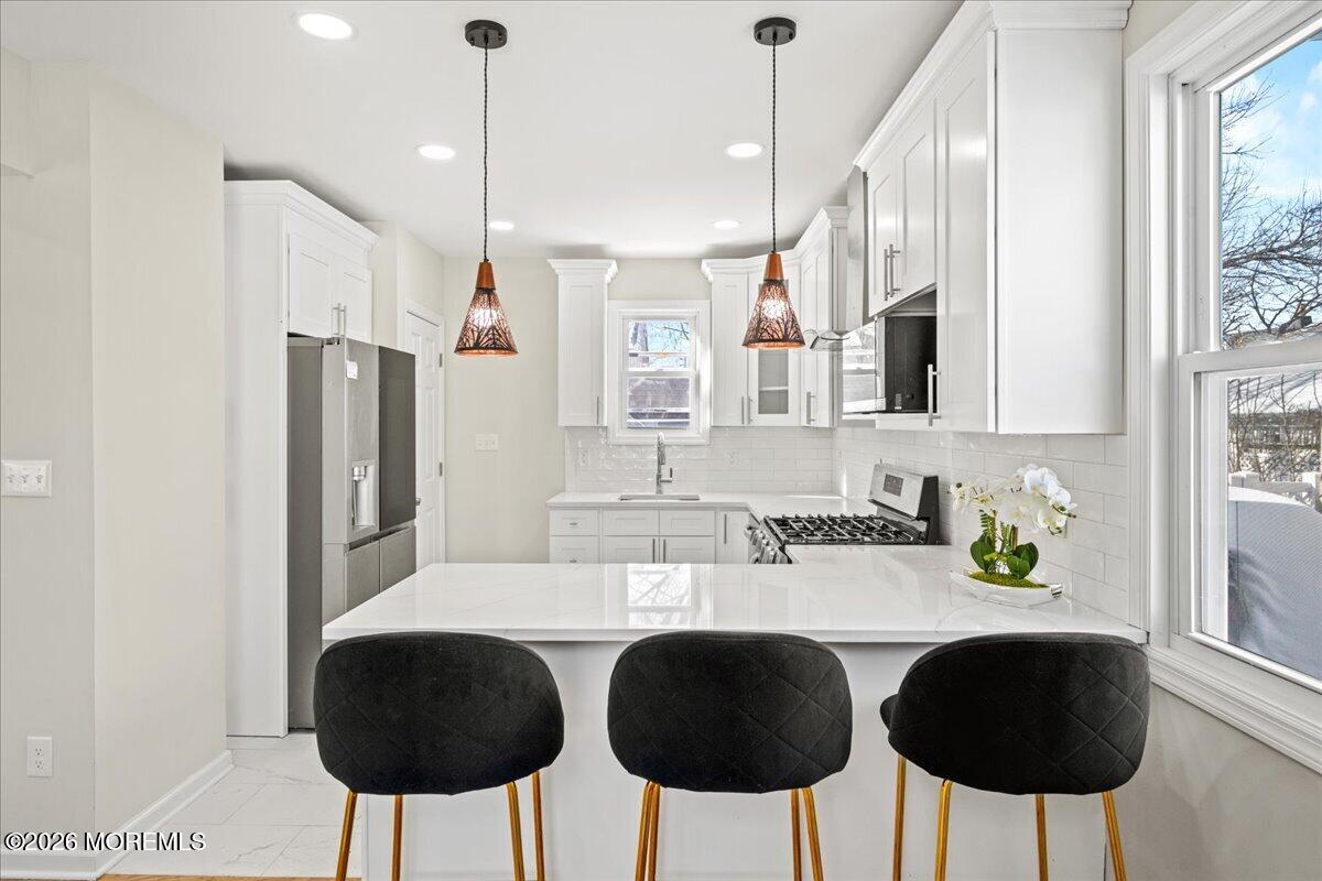 20 Elston Street Bloomfield, NJ 07003 - Photo 15 of 43 a kitchen with stainless steel appliances a sink a table and chairs in it