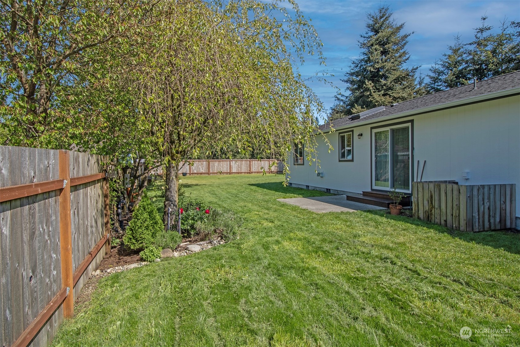 17836 Camus Drive Southwest Rochester, WA 98579 - Photo 20 of 27 a view of a backyard with large trees and wooden fence