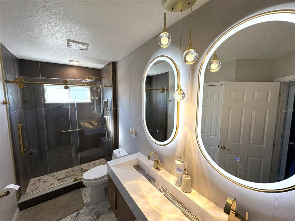 1431 Spring Fest Lane Orlando, FL 32828 - Photo 19 of 36 a bathroom with a toilet a sink and mirror