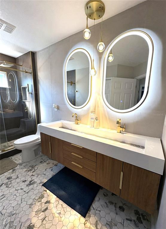 1431 Spring Fest Lane Orlando, FL 32828 - Photo 20 of 36 a bathroom with a toilet a sink and mirror