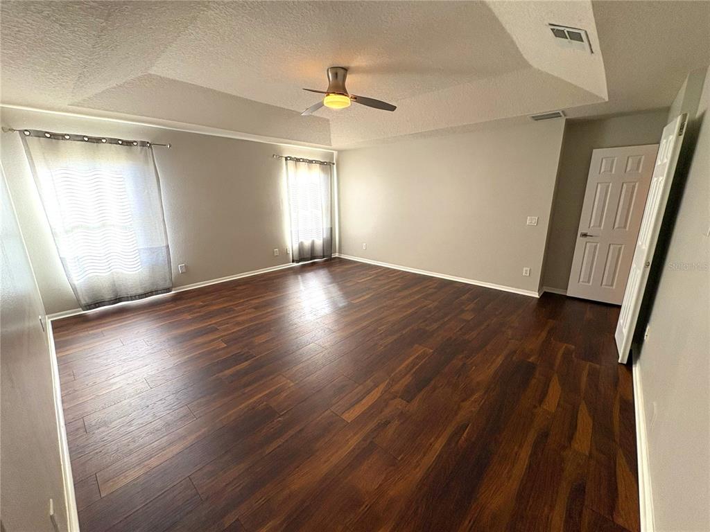1431 Spring Fest Lane Orlando, FL 32828 - Photo 23 of 36 an empty room with wooden floor and windows