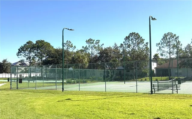 a swimming pool with lots of trees and wooden fence