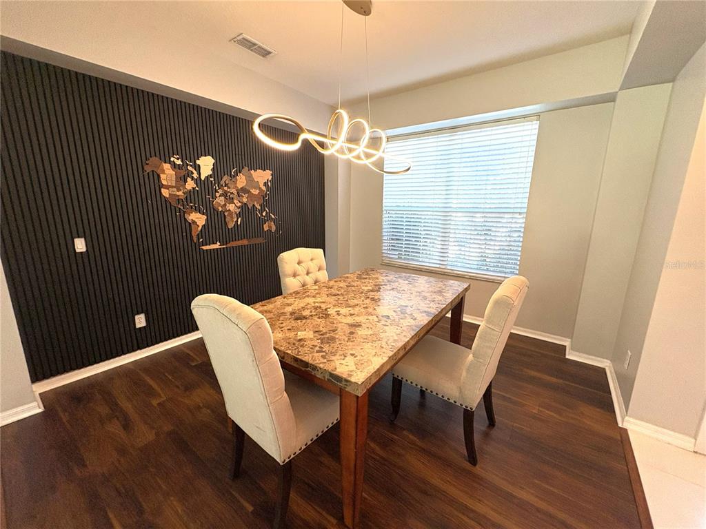 1431 Spring Fest Lane Orlando, FL 32828 - Photo 4 of 36 a view of a dining room with furniture a chandelier and wooden floor