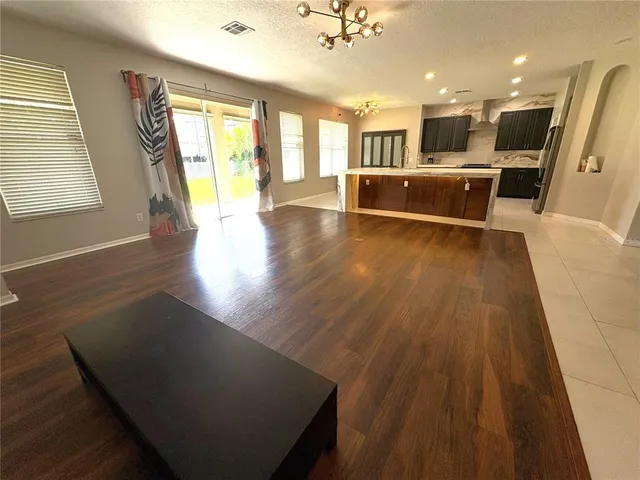 a living room with stainless steel appliances kitchen island granite countertop furniture and a large window