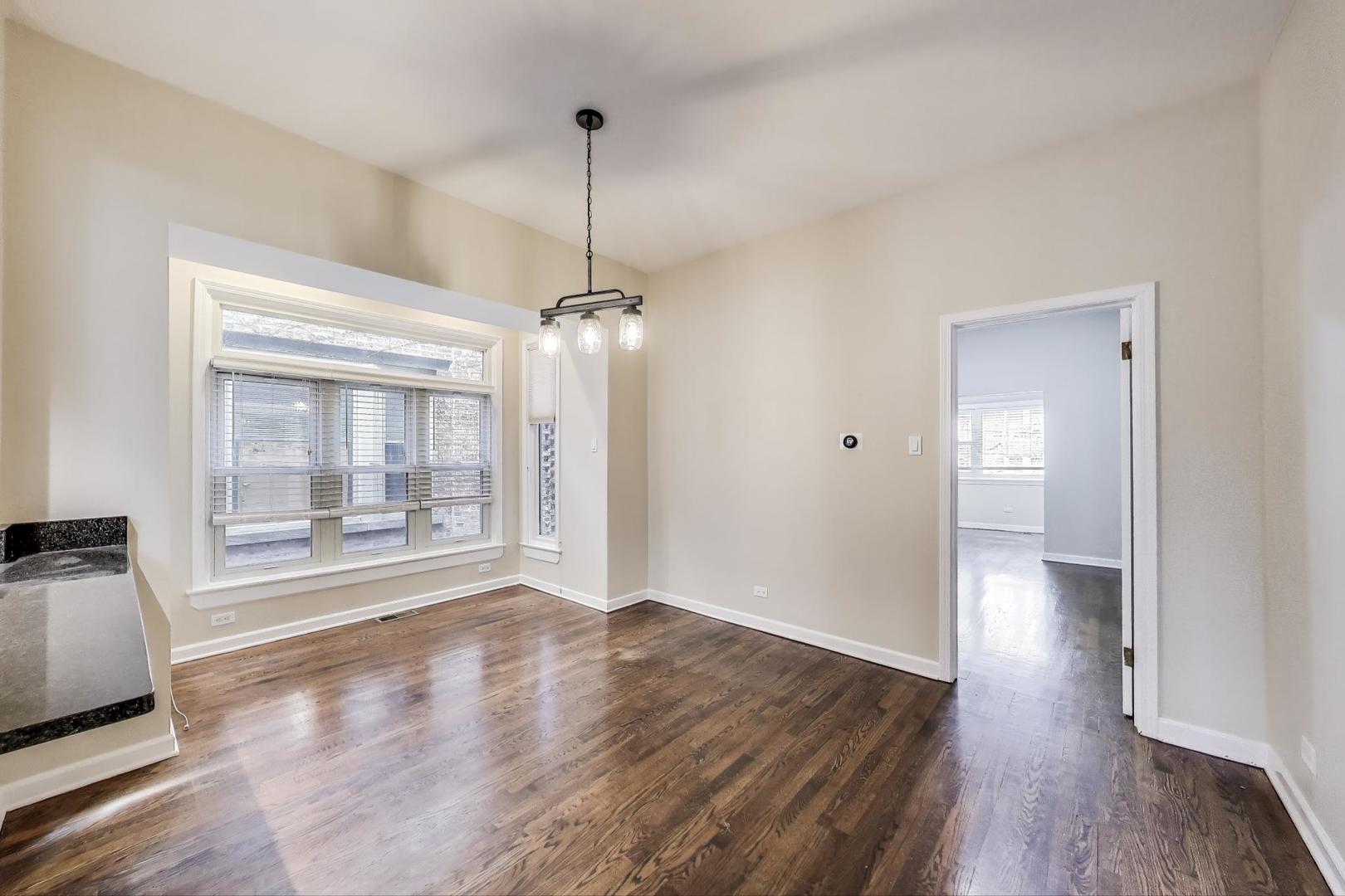 636 West Grace Street, Unit 2W Chicago, IL 60613 - Photo 11 of 26 a view of an empty room with wooden floor and a window