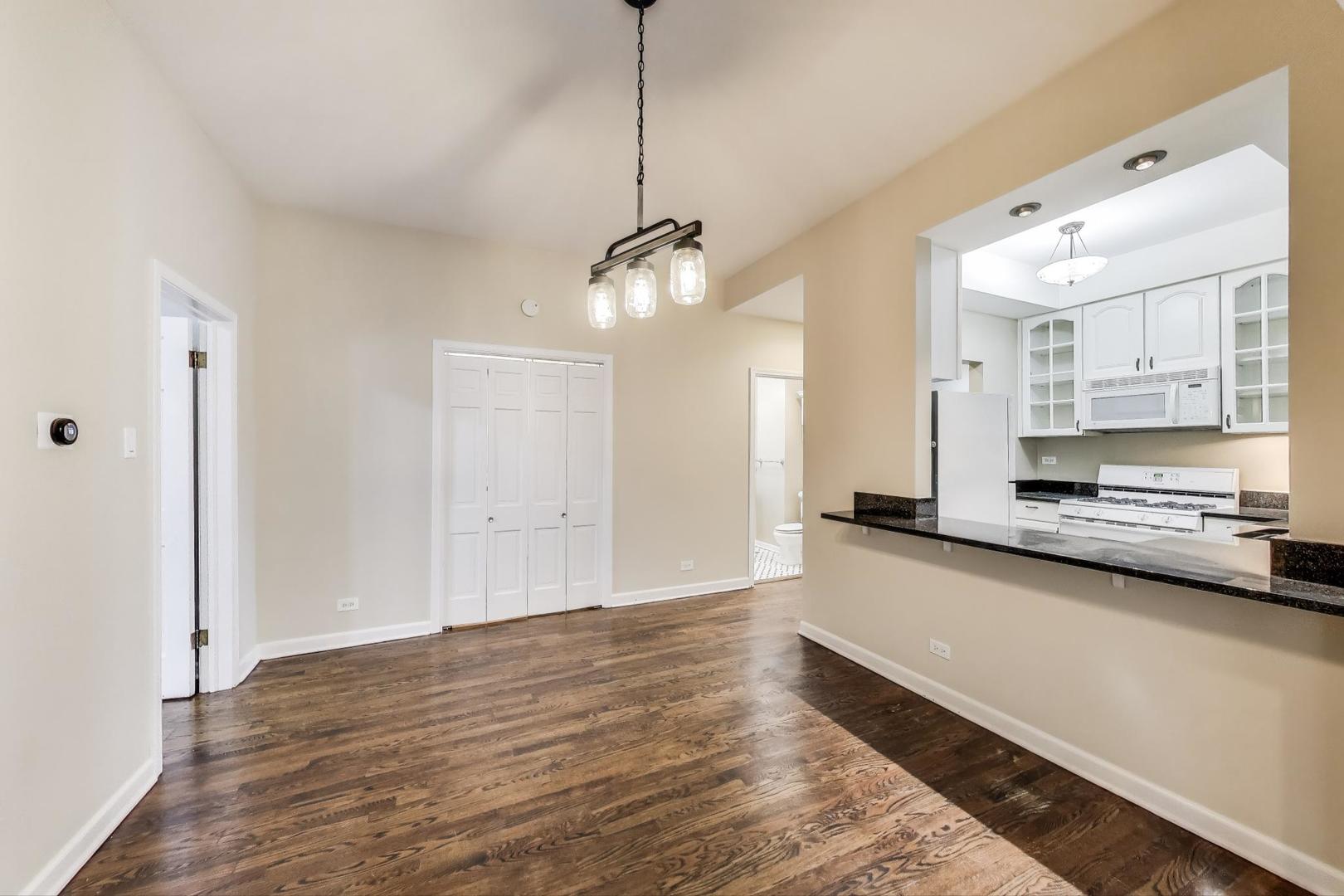 636 West Grace Street, Unit 2W Chicago, IL 60613 - Photo 12 of 26 a large kitchen with stainless steel appliances a large counter top a stove and a refrigerator