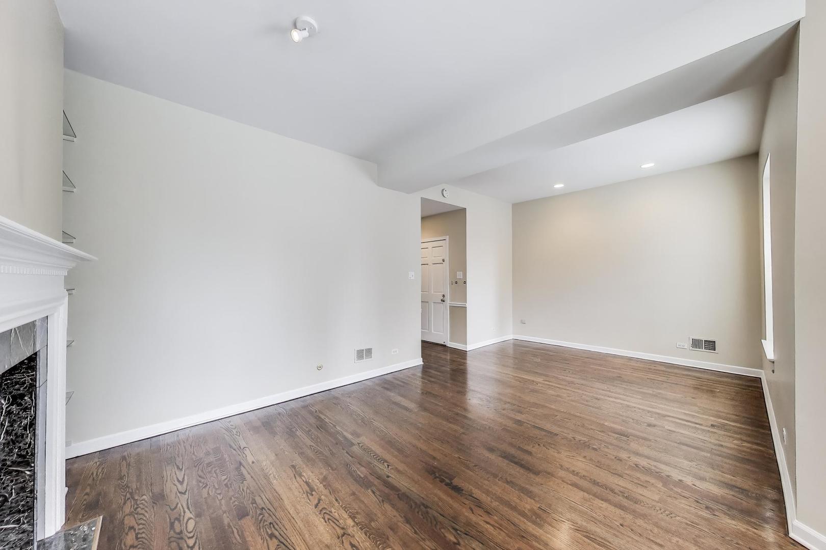 636 West Grace Street, Unit 2W Chicago, IL 60613 - Photo 4 of 26 a view of an empty room with wooden floor and a window