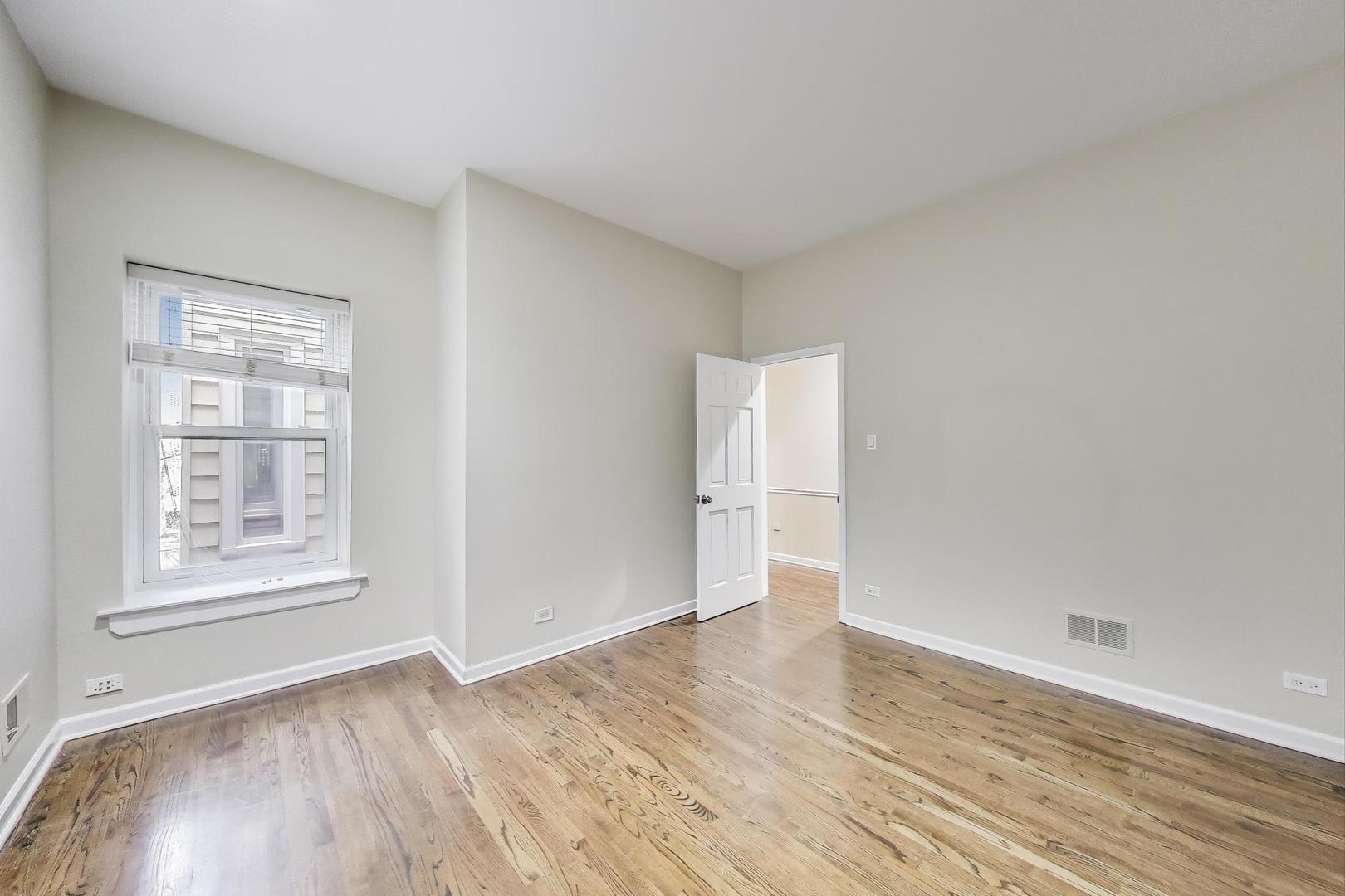 636 West Grace Street, Unit 2W Chicago, IL 60613 - Photo 5 of 26 an empty room with wooden floor and windows