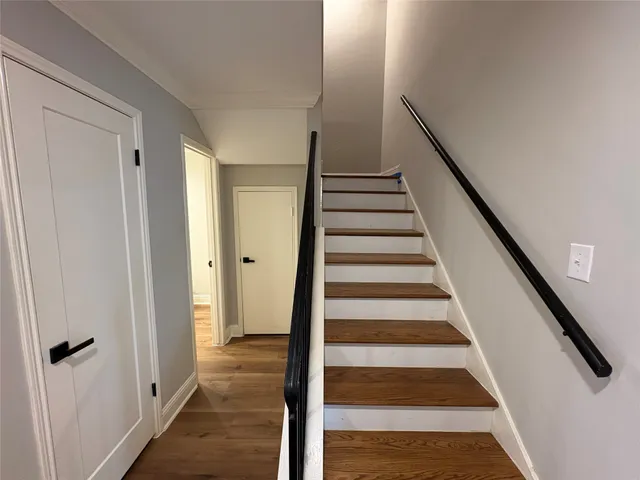a view of a hallway with wooden floor and entryway