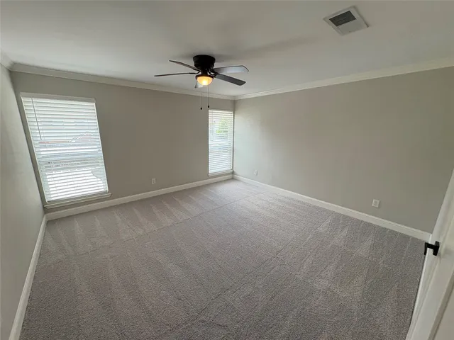 an empty room with windows and fan