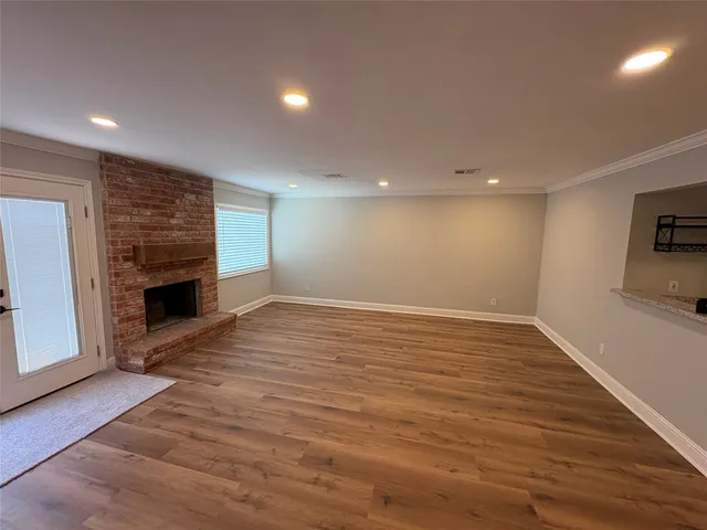 a view of empty room with wooden floor and fireplace
