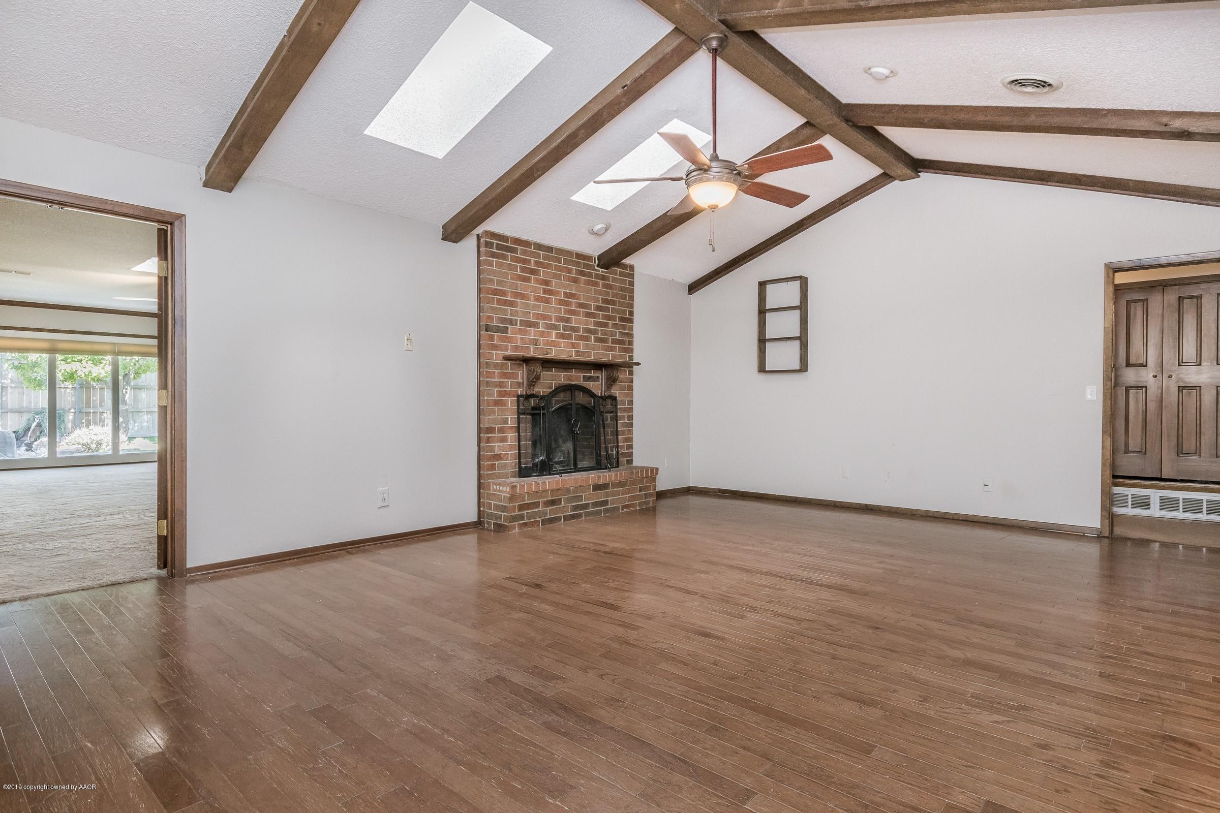 5610 Southwest 41st Avenue Amarillo, TX 79109 - Photo 2 of 30 a view of an empty room with wooden floor fireplace and a window