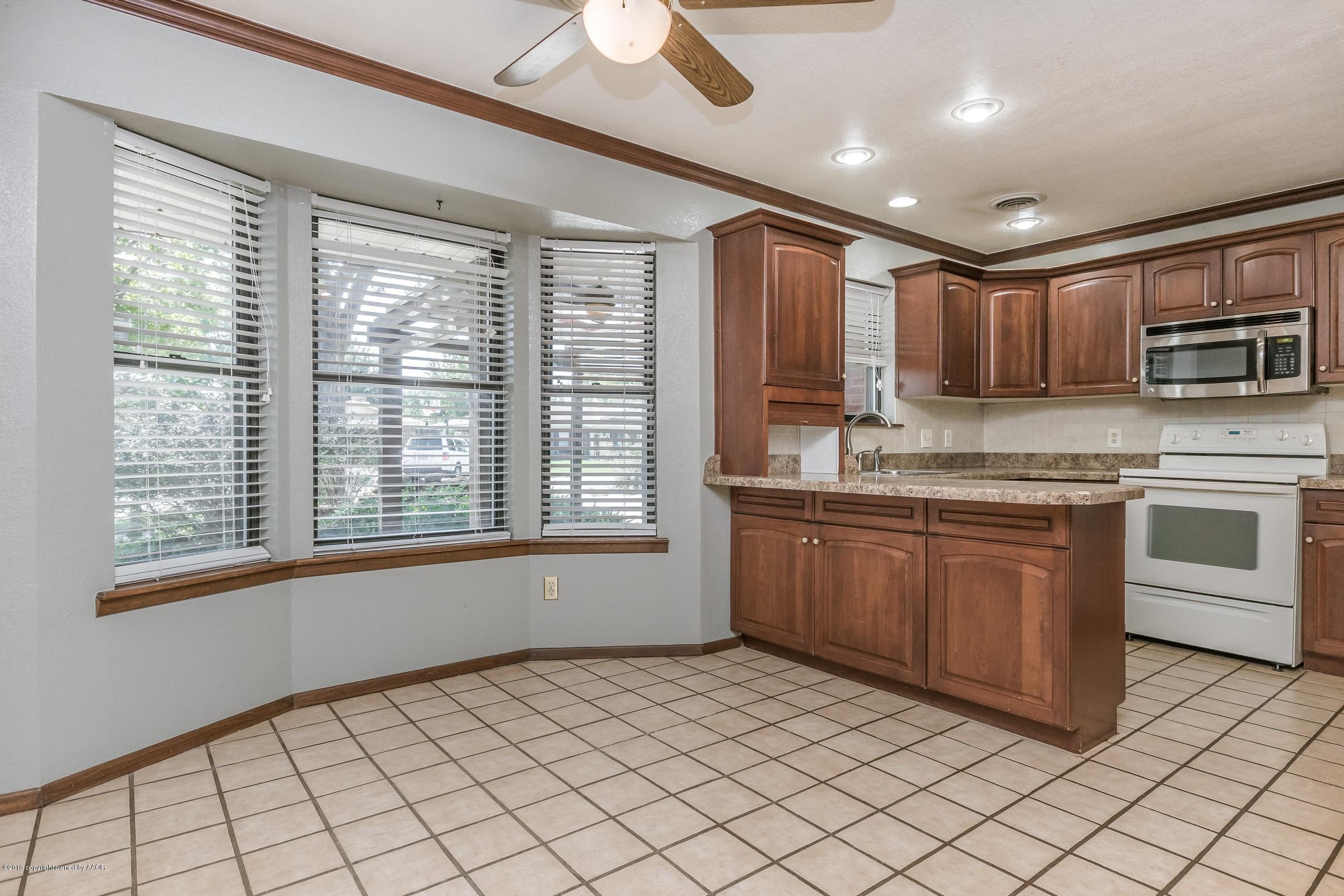 5610 Southwest 41st Avenue Amarillo, TX 79109 - Photo 3 of 30 a large kitchen with stainless steel appliances granite countertop a stove a sink and a microwave