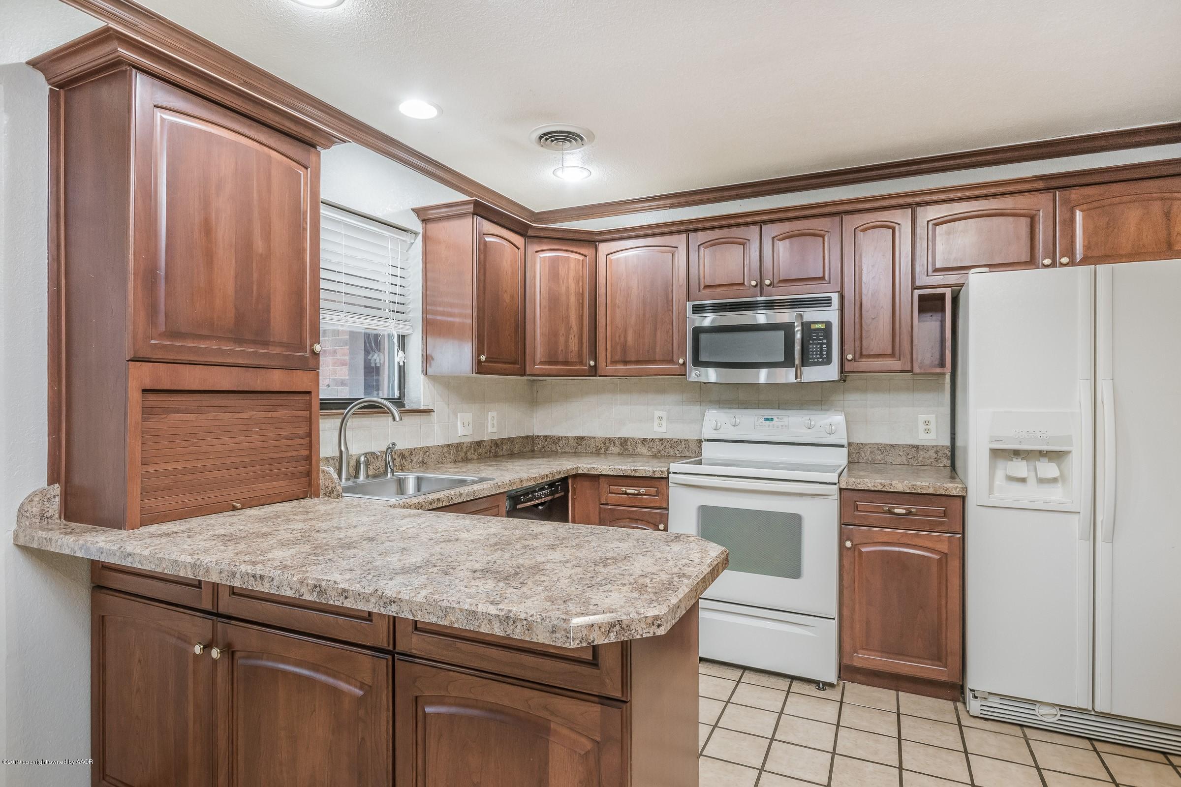 5610 Southwest 41st Avenue Amarillo, TX 79109 - Photo 4 of 30 a kitchen with stainless steel appliances granite countertop a refrigerator sink and stove
