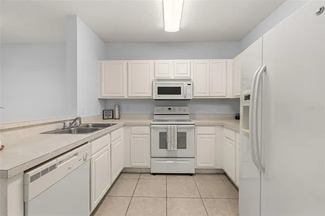 a kitchen with white cabinets and white appliances