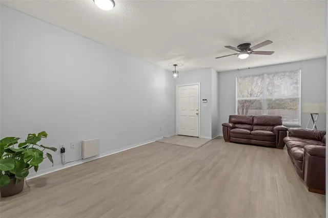a living room with furniture and a ceiling fan