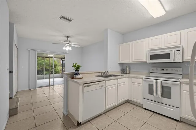 a kitchen with white cabinets and appliances