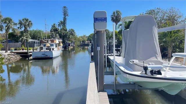 a view of a lake with couches chairs and potted plants