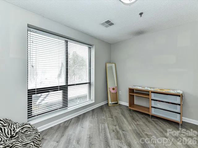 a view of a room with baby crib and a window