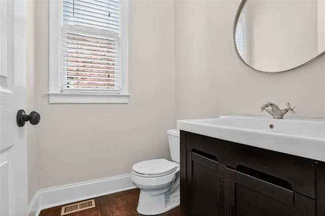 a bathroom with a sink a toilet and a mirror