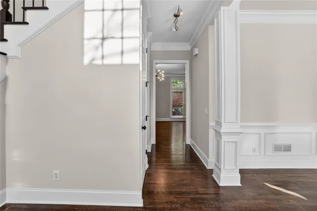 a view of a hallway with wooden floor and staircase