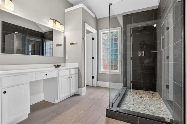 a spacious bathroom with a shower sink and mirror