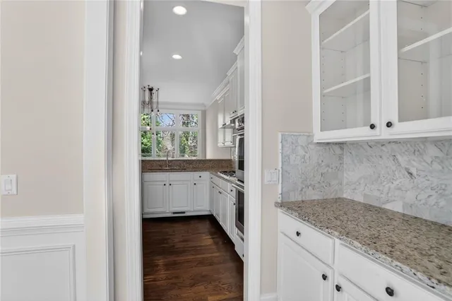 a view of a kitchen with white cabinets and wooden floor