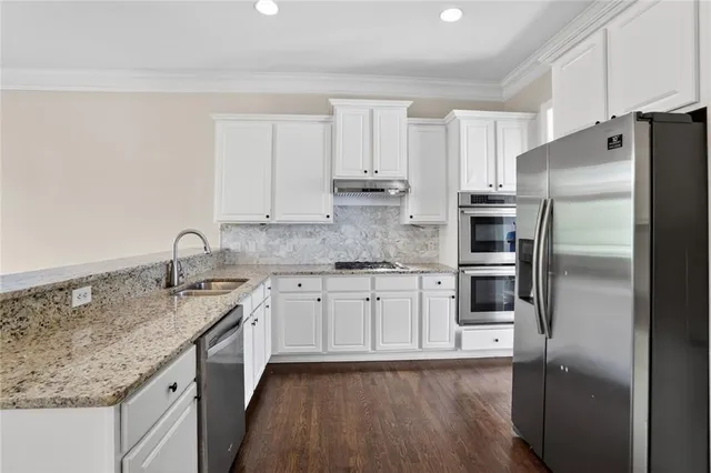 a kitchen with stainless steel appliances granite countertop a refrigerator sink and cabinets