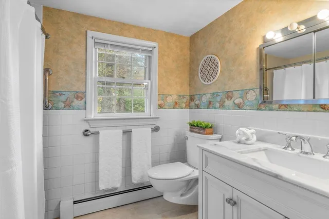 a bathroom with a sink a toilet and a window