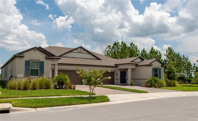 a front view of a house with a garden and trees