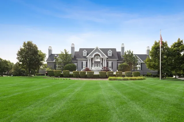a view of a house with a big yard and large trees