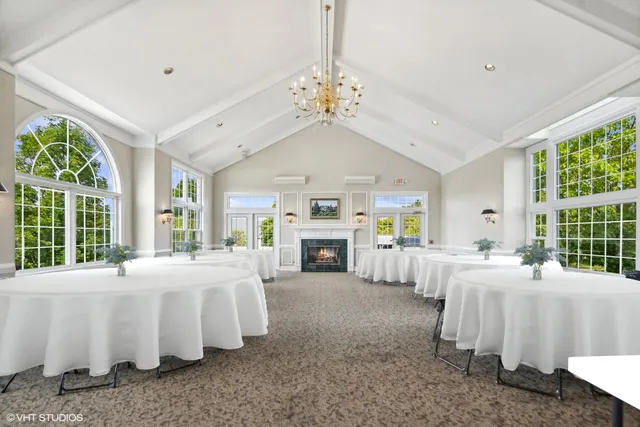 a large white bedroom with a large bed and a fireplace