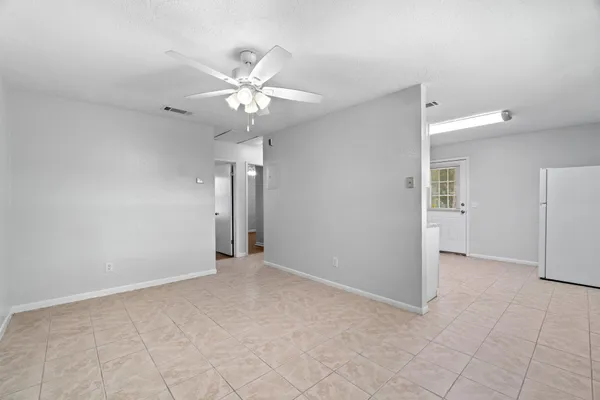 an empty room with closet and a chandelier fan