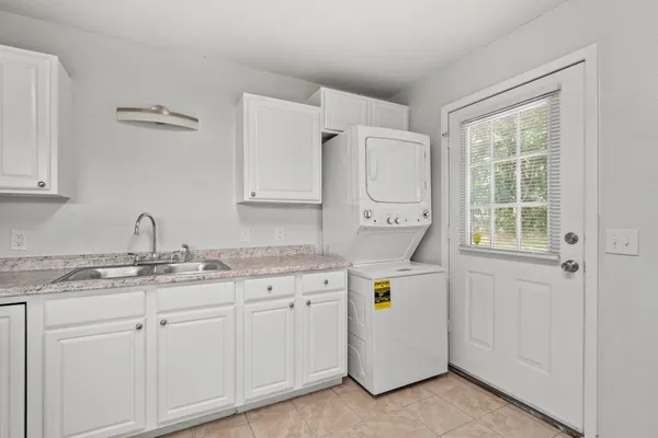 a view of cabinets a sink and a stove in a room