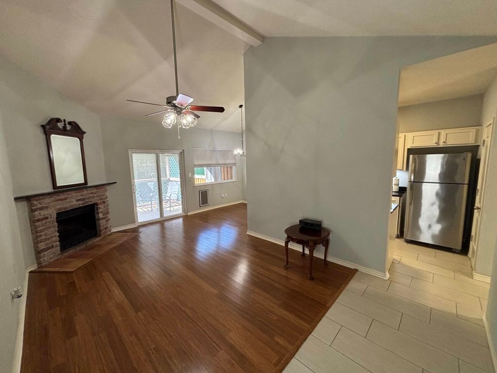 307 Quarry Street San Marcos, TX 78666 - Photo 2 of 38 Unfurnished living room featuring a fireplace, beamed ceiling, a ceiling fan, light wood-type flooring, and high vaulted ceiling
