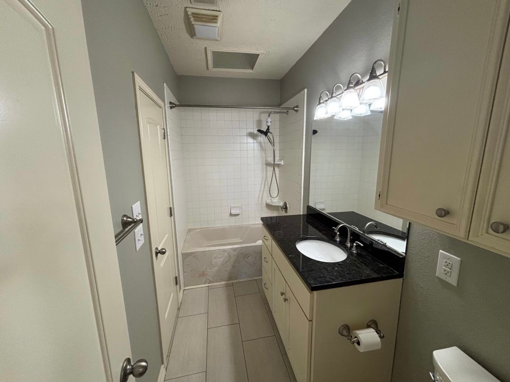 307 Quarry Street San Marcos, TX 78666 - Photo 23 of 38 Bathroom with shower / bathtub combination, vanity, a textured ceiling, and light tile patterned floors