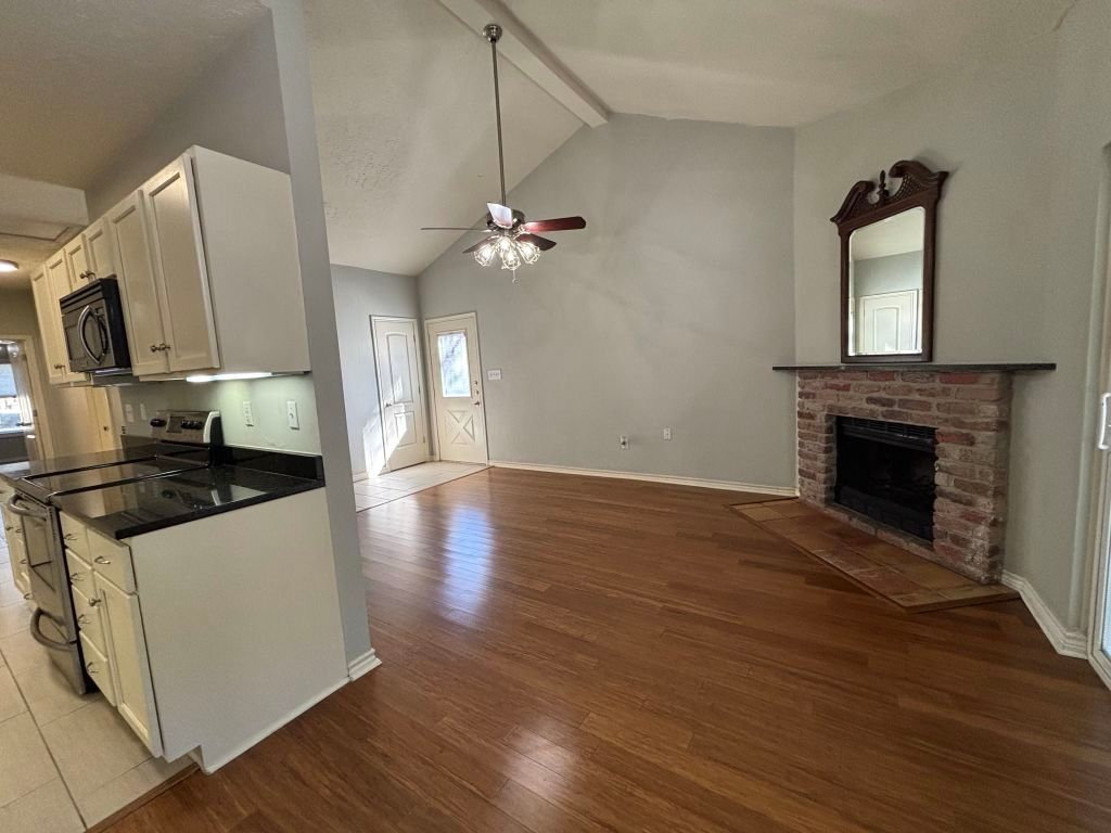 307 Quarry Street San Marcos, TX 78666 - Photo 38 of 38 Kitchen featuring white cabinets, electric stove, dark wood-style floors, a fireplace, and open floor plan