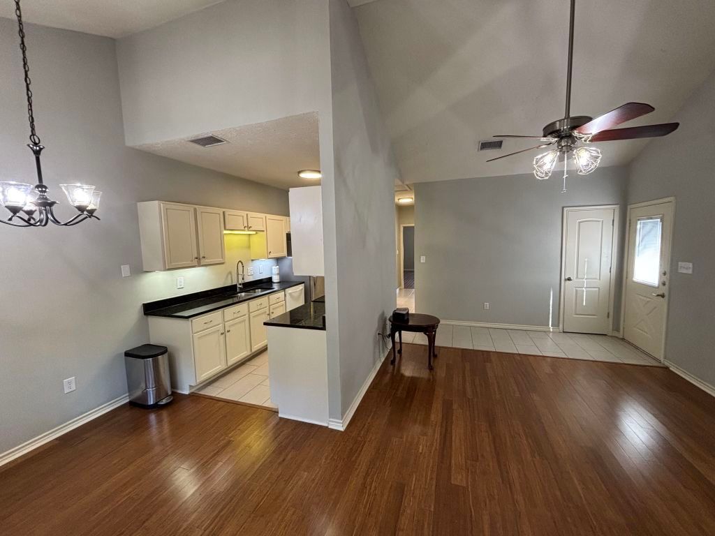 307 Quarry Street San Marcos, TX 78666 - Photo 9 of 38 Kitchen with a ceiling fan, a chandelier, high vaulted ceiling, dark wood-type flooring, and pendant lighting