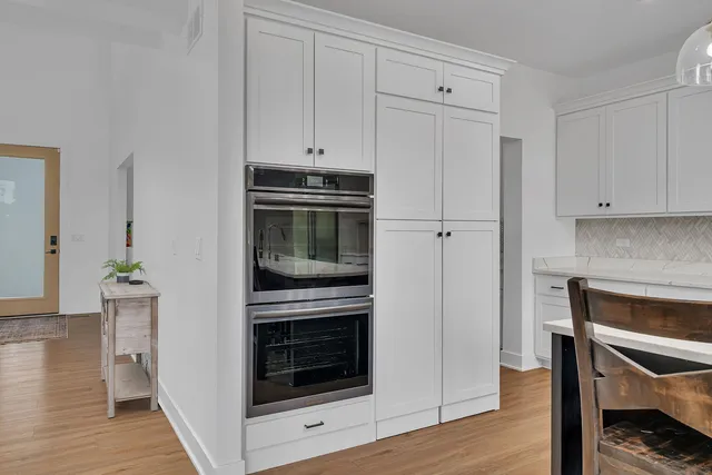 a kitchen with white cabinets and appliances