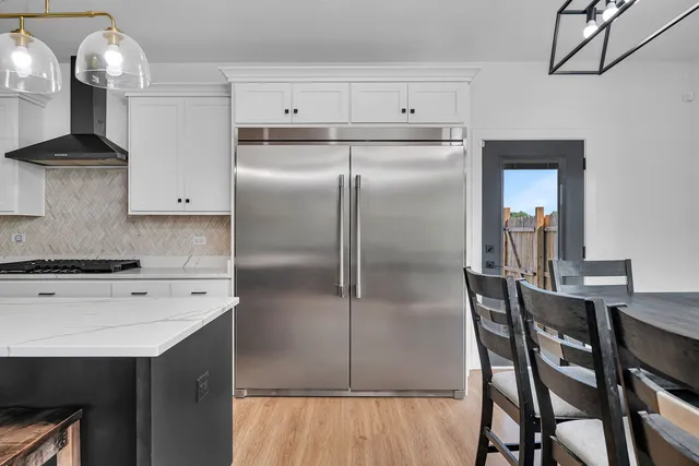a kitchen with a refrigerator a sink and cabinets