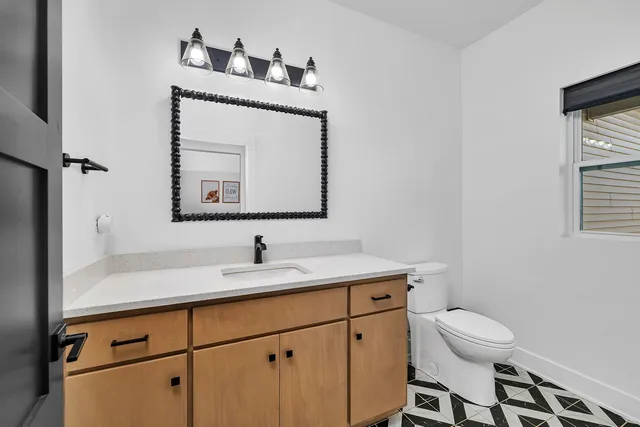 a bathroom with a toilet a sink and mirror