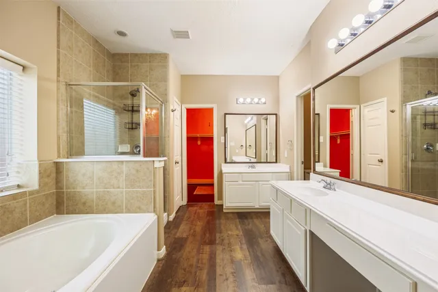 a bathroom with a bathtub a sink and a large mirror