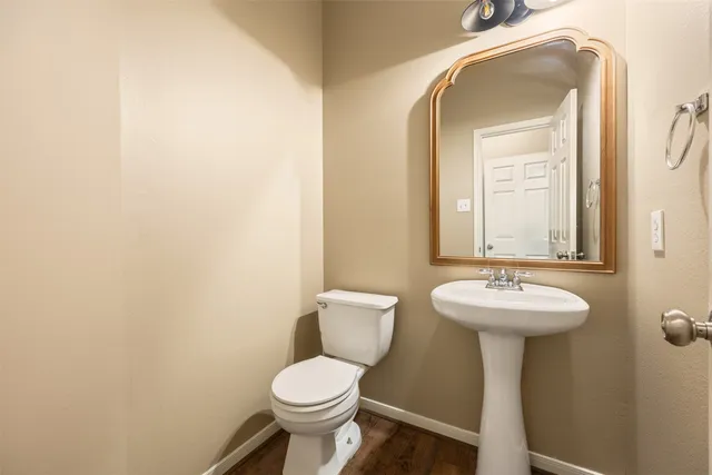a bathroom with a toilet sink and mirror