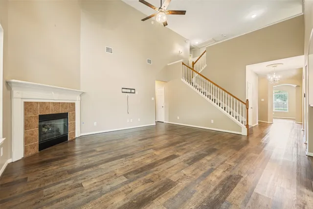 a view of an empty room with wooden floor a fireplace