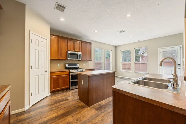 a kitchen with stainless steel appliances granite countertop a sink stove and refrigerator