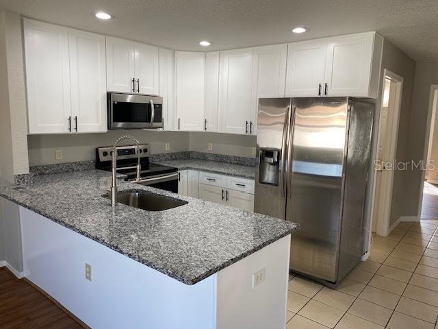 8427 Southwest 136th Street Ocala, FL 34473 - Photo 9 of 18 a kitchen with stainless steel appliances granite countertop a refrigerator a stove a sink and a microwave