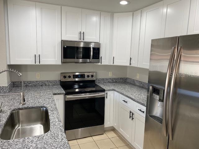 8427 Southwest 136th Street Ocala, FL 34473 - Photo 10 of 18 a kitchen with stainless steel appliances granite countertop a sink stove and refrigerator