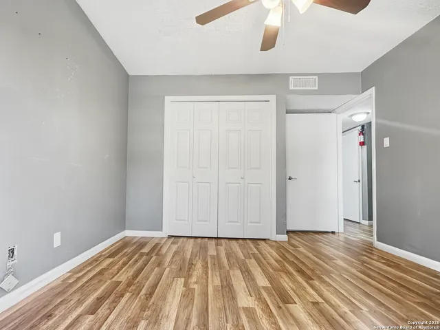 a large bedroom with a bed wooden floor and furniture
